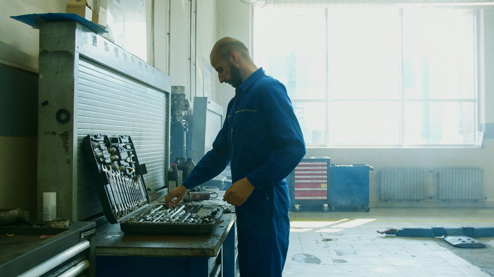 Auto glass repairer in his garage looking into a toolbox