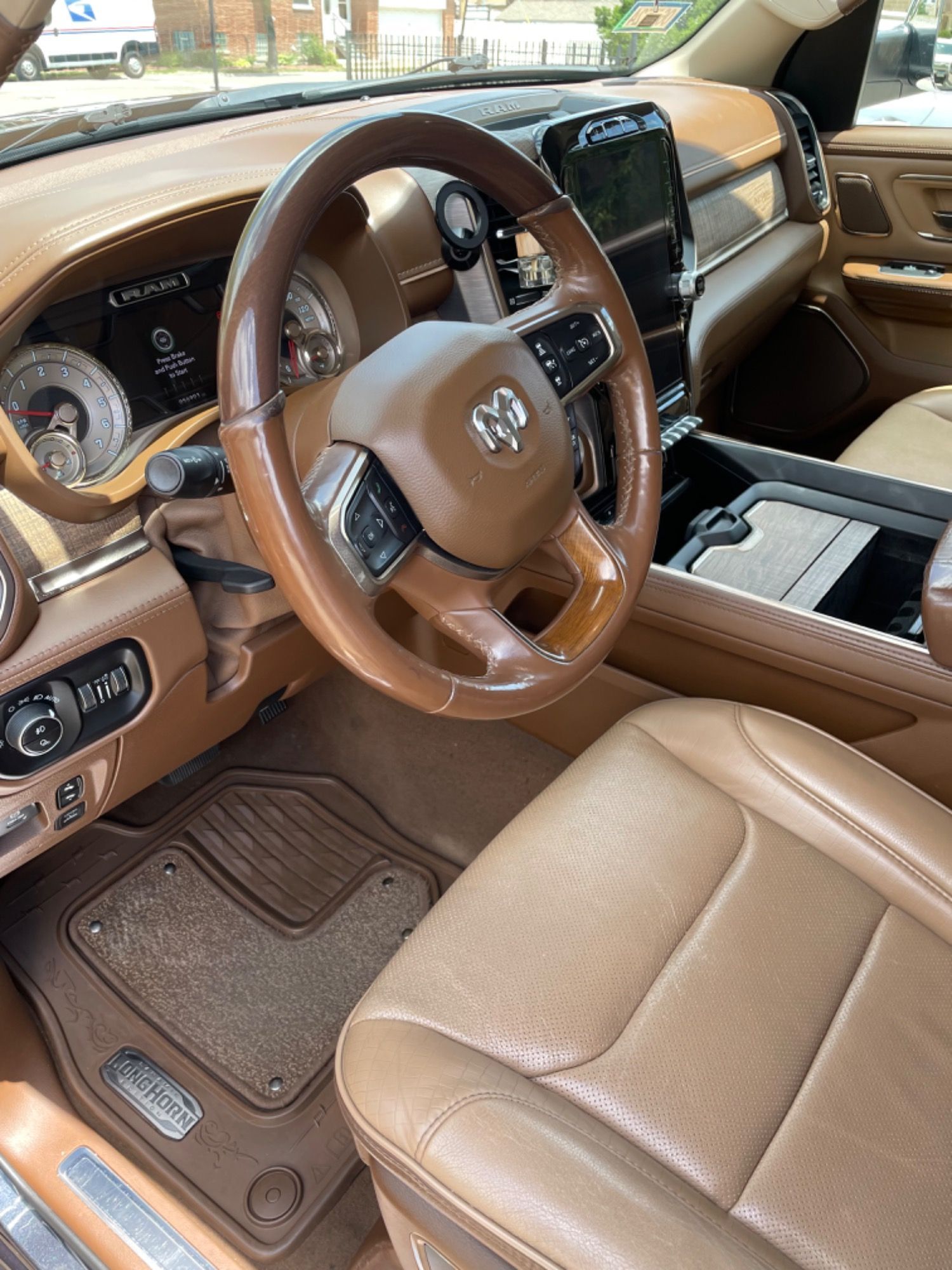 The interior of a ram truck with brown leather seats and a steering wheel.
