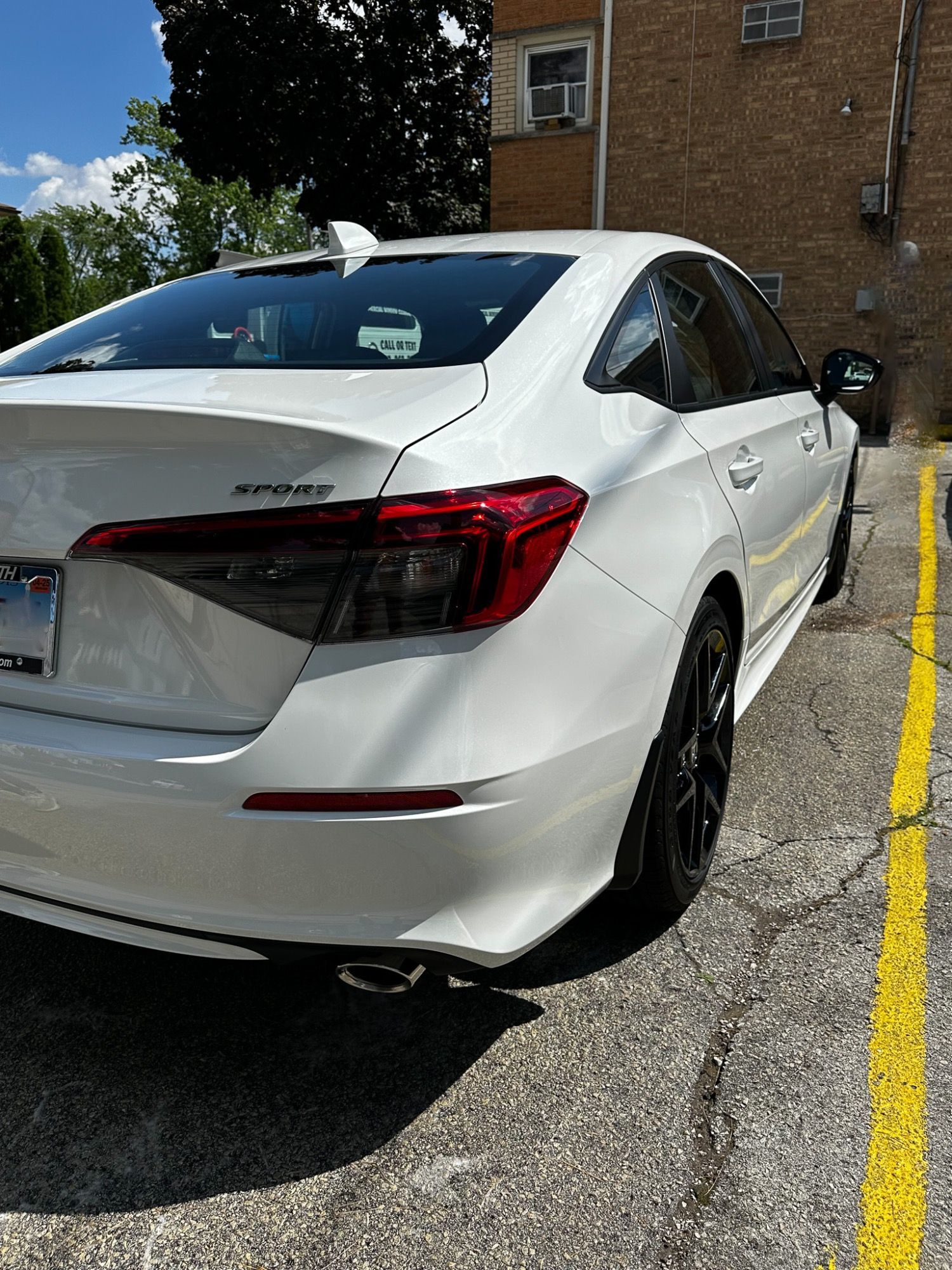 A white honda accord is parked in a parking lot.
