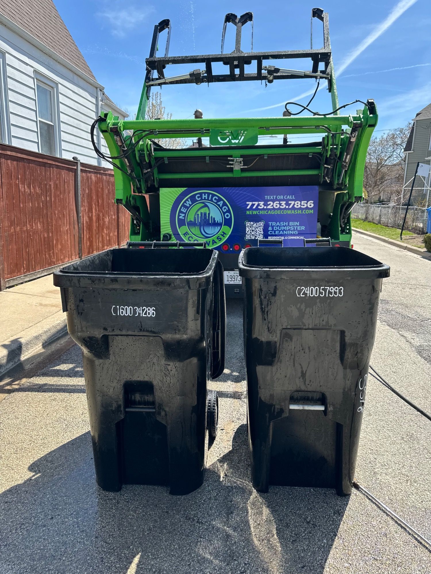 Two garbage cans are sitting next to each other on the side of the road.