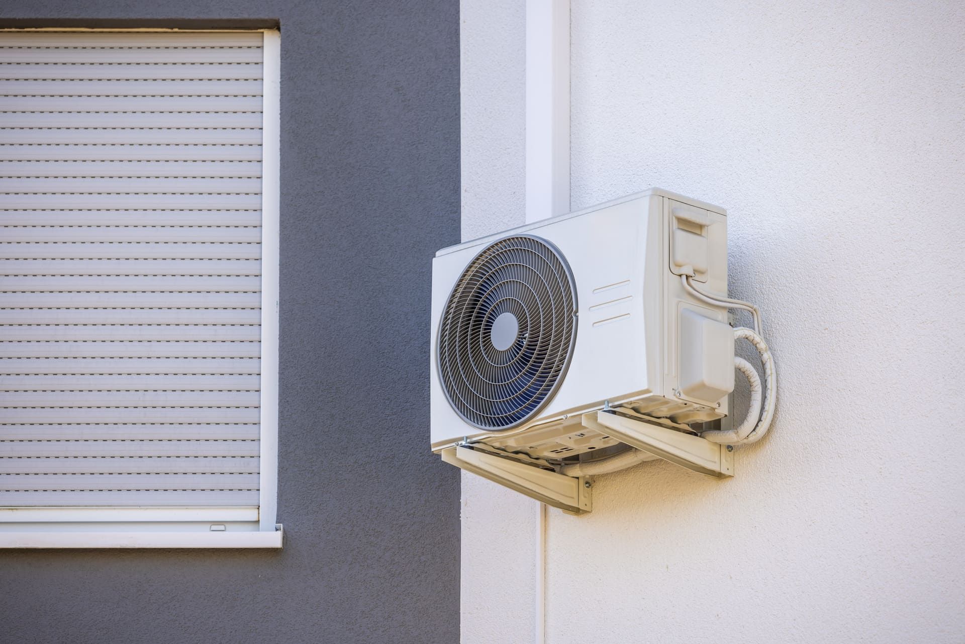 Air conditioner and heat pump installed on a wall of family house, split system unit