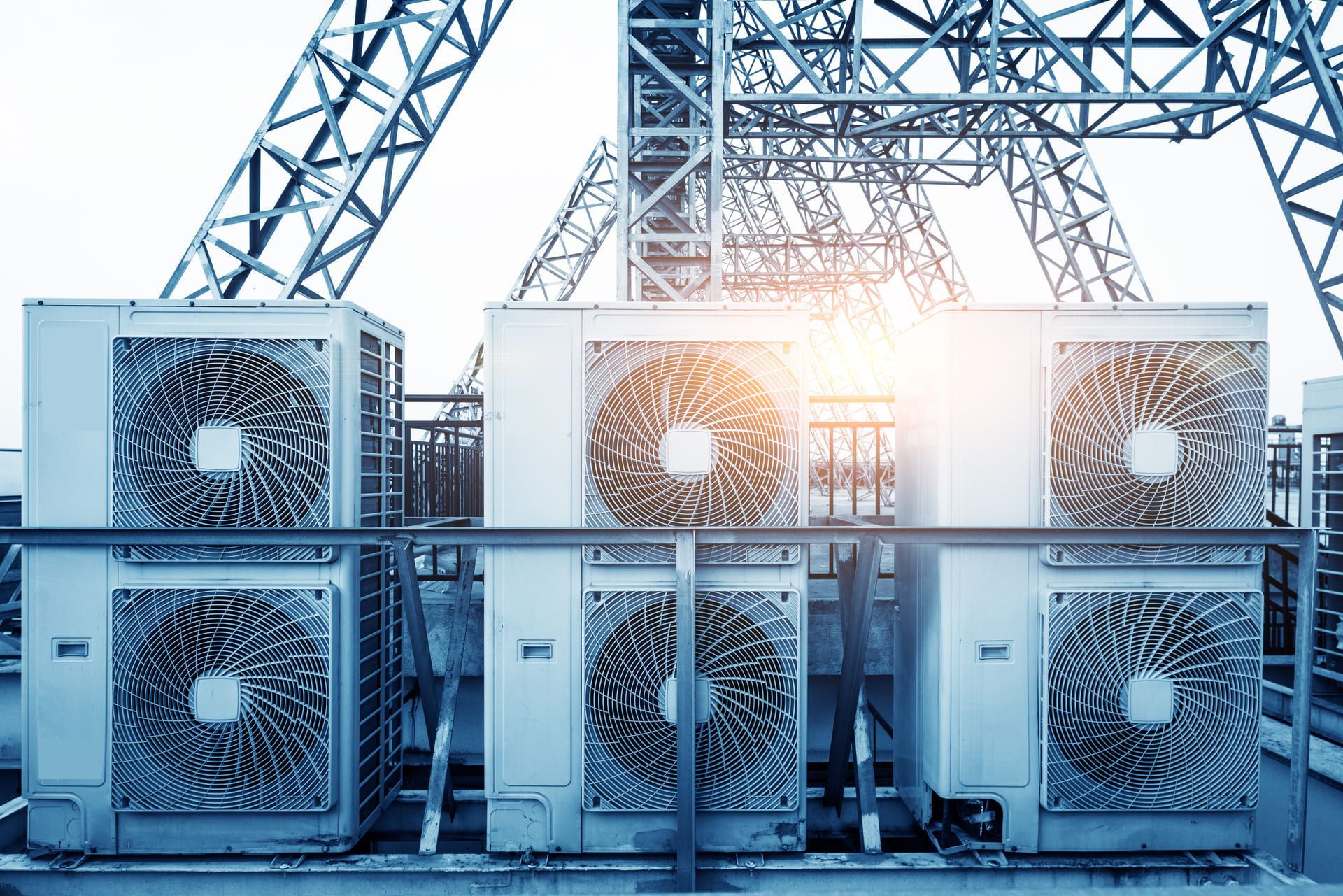 Air conditioner units (HVAC) on a roof of industrial building with blue sky and clouds in the background