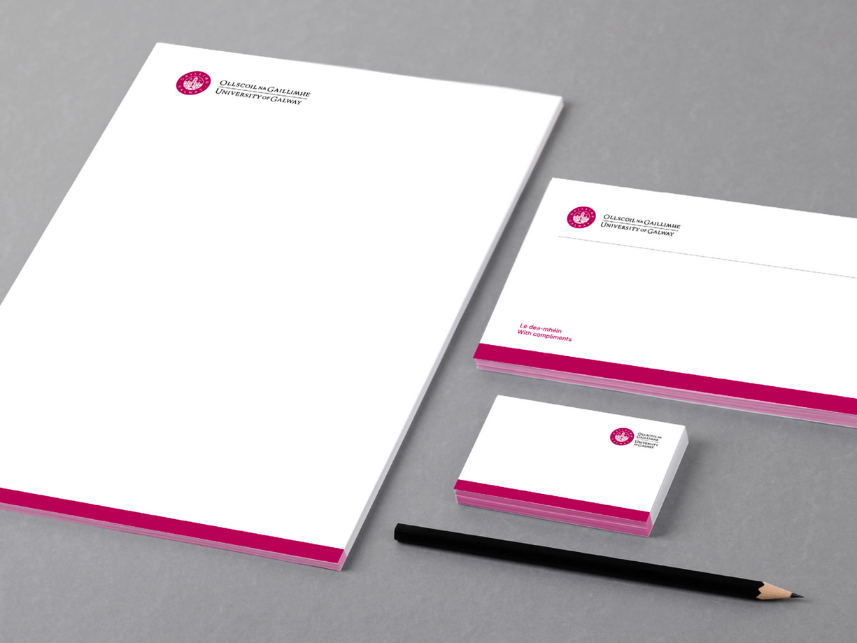 A set of business cards , envelopes , and a pencil on a table.