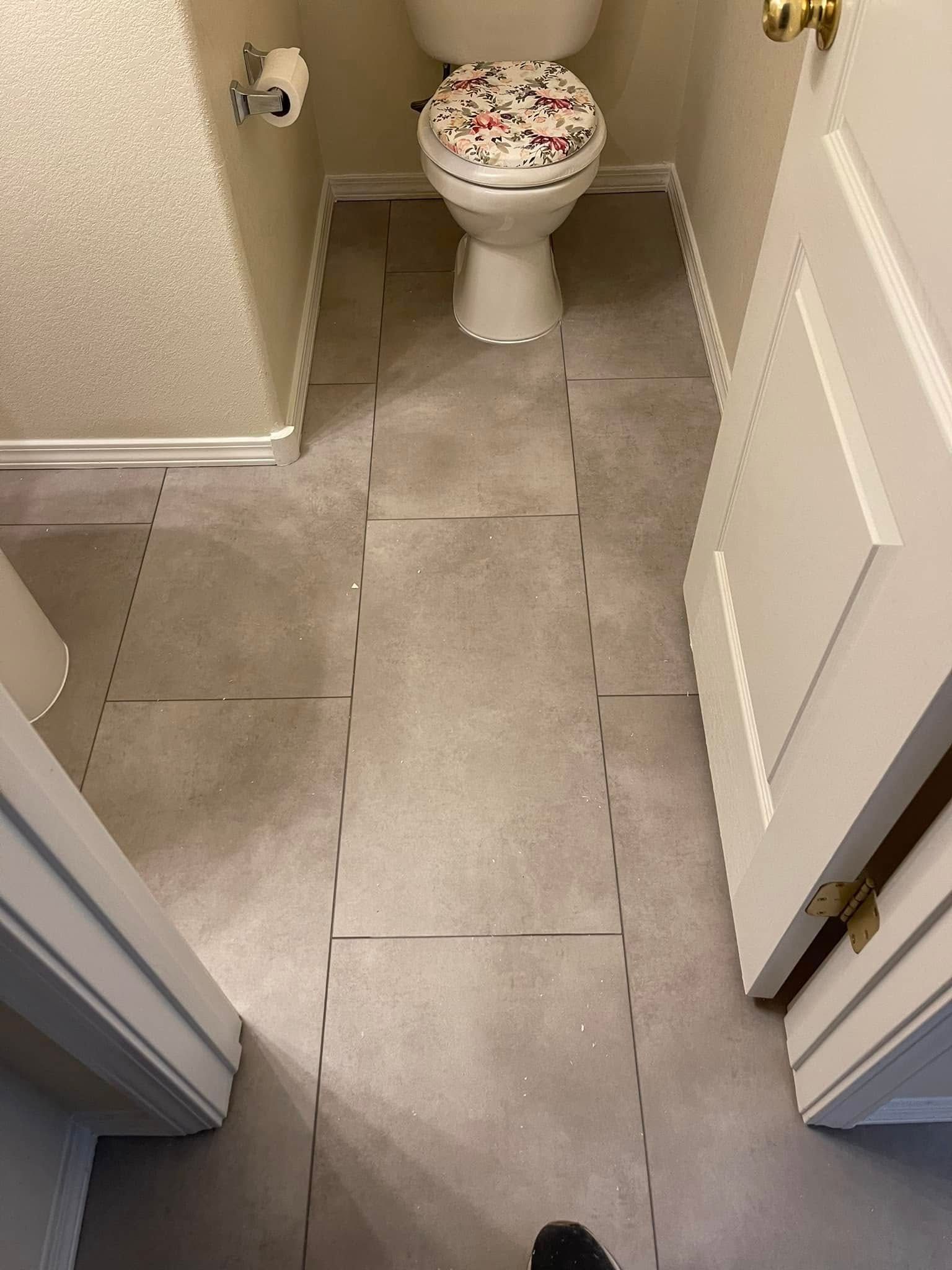 Narrow bathroom with gray tile floor and a white toilet centered at the back.