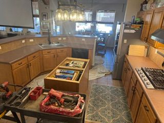 Kitchen under renovation with cabinets, tools, and a central island in progress