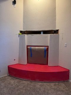 Red carpeted stage with a small central podium and blue ribbons against a plain wall