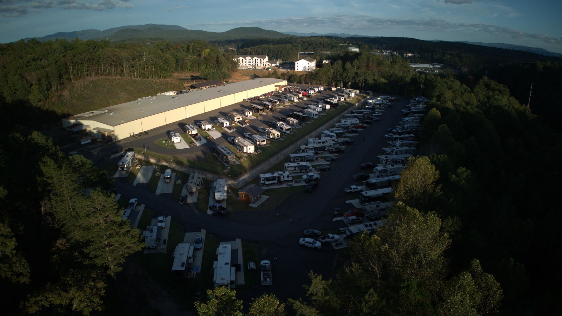 A row of rvs are parked on the side of a dirt road.