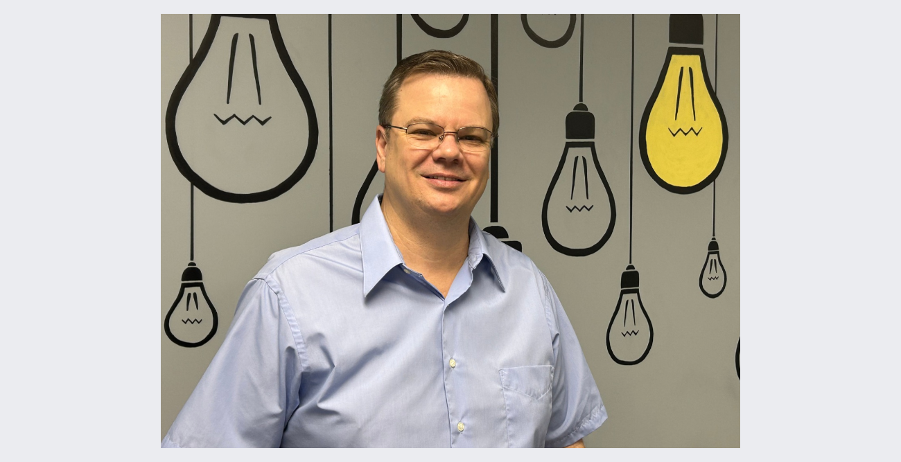 A man in a suit and tie has a lanyard around his neck that says ' ucsd ' on it