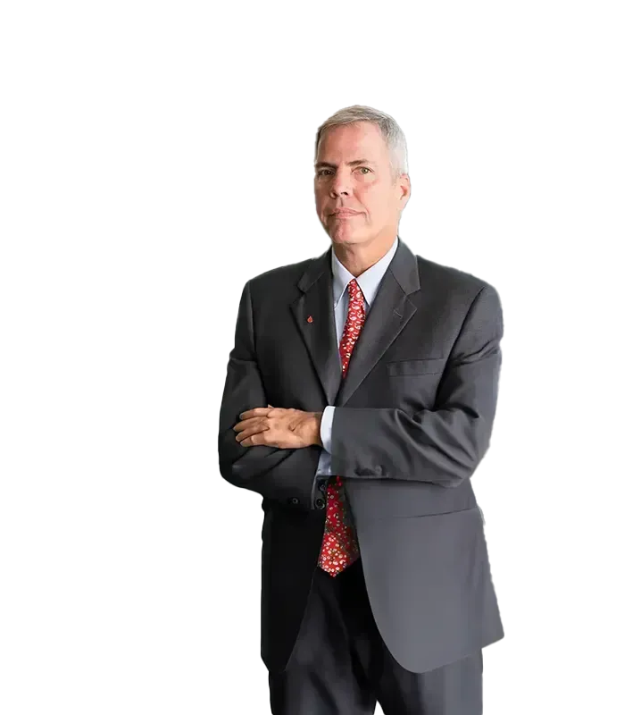 A man in a suit and tie is standing with his arms crossed