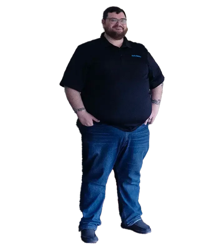 A man with a beard is standing with his hands in his pockets