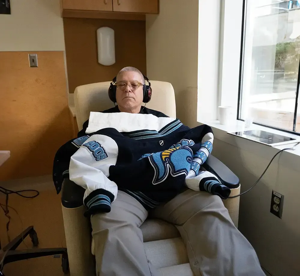 A man wearing headphones and a jacket with the letter j on it