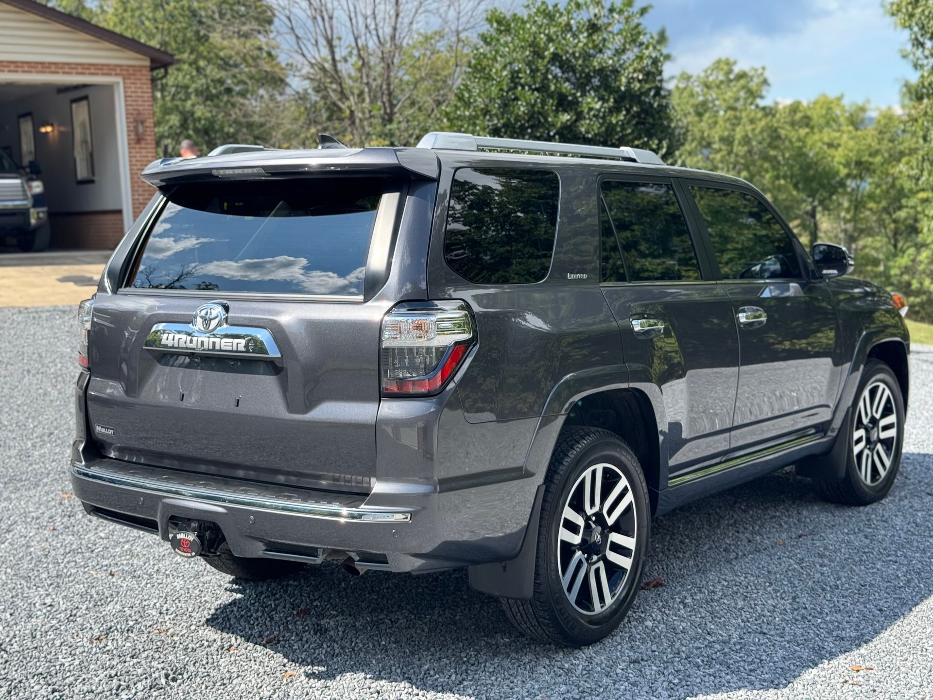 Dark gray Toyota 4Runner SUV parked on a gravel driveway.