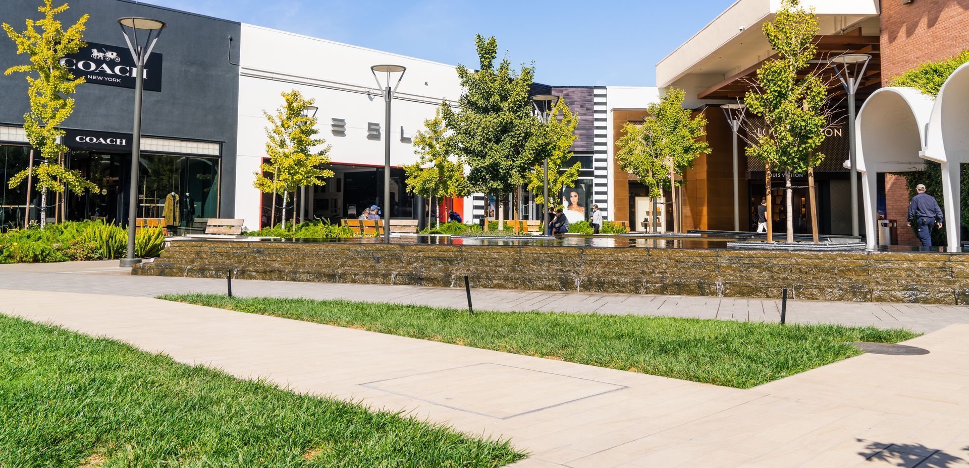 Un centre commercial avec beaucoup de magasins et d'arbres devant lui.