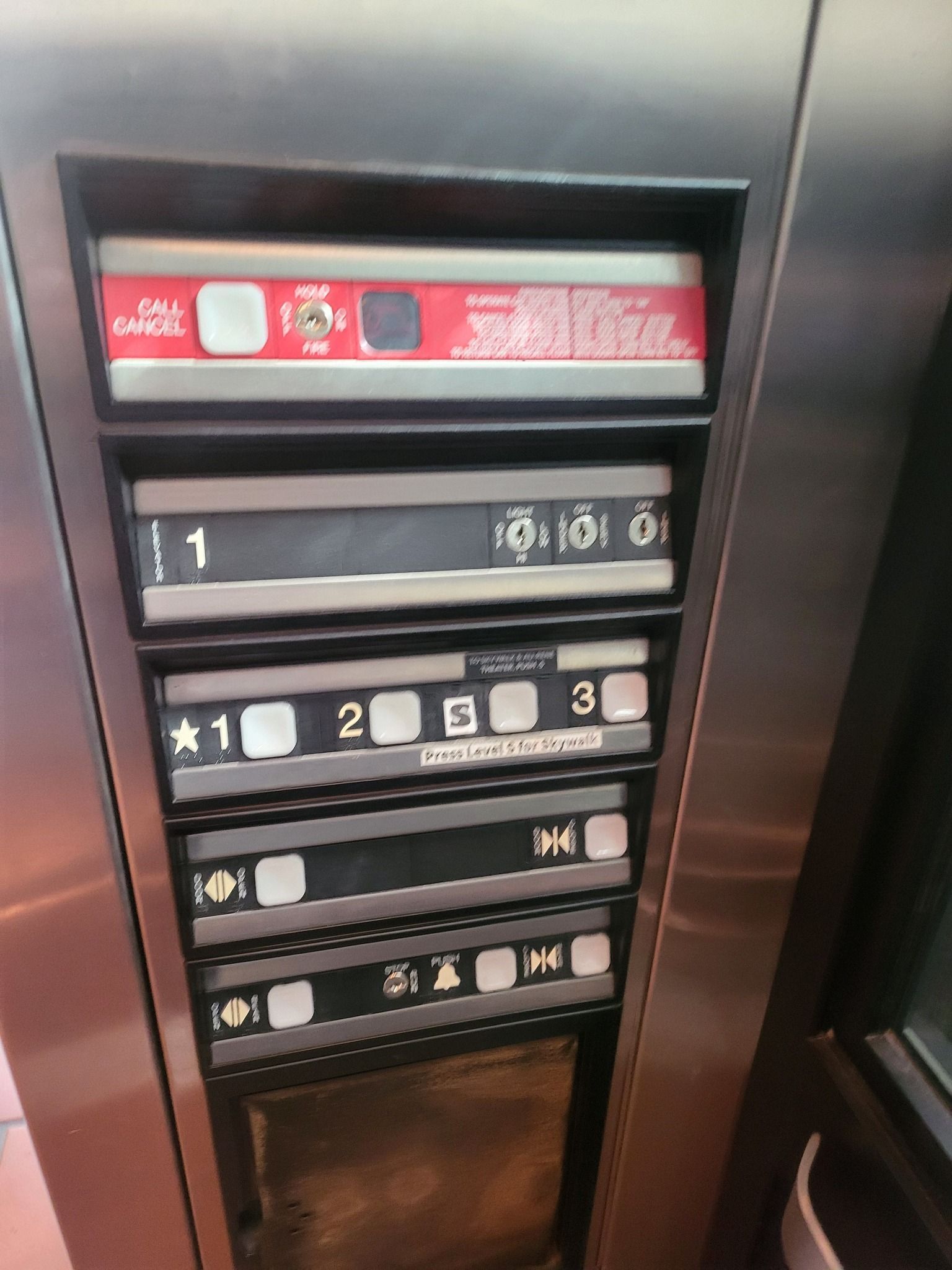 Elevator control panel with floor buttons, door open/close controls, and emergency labels