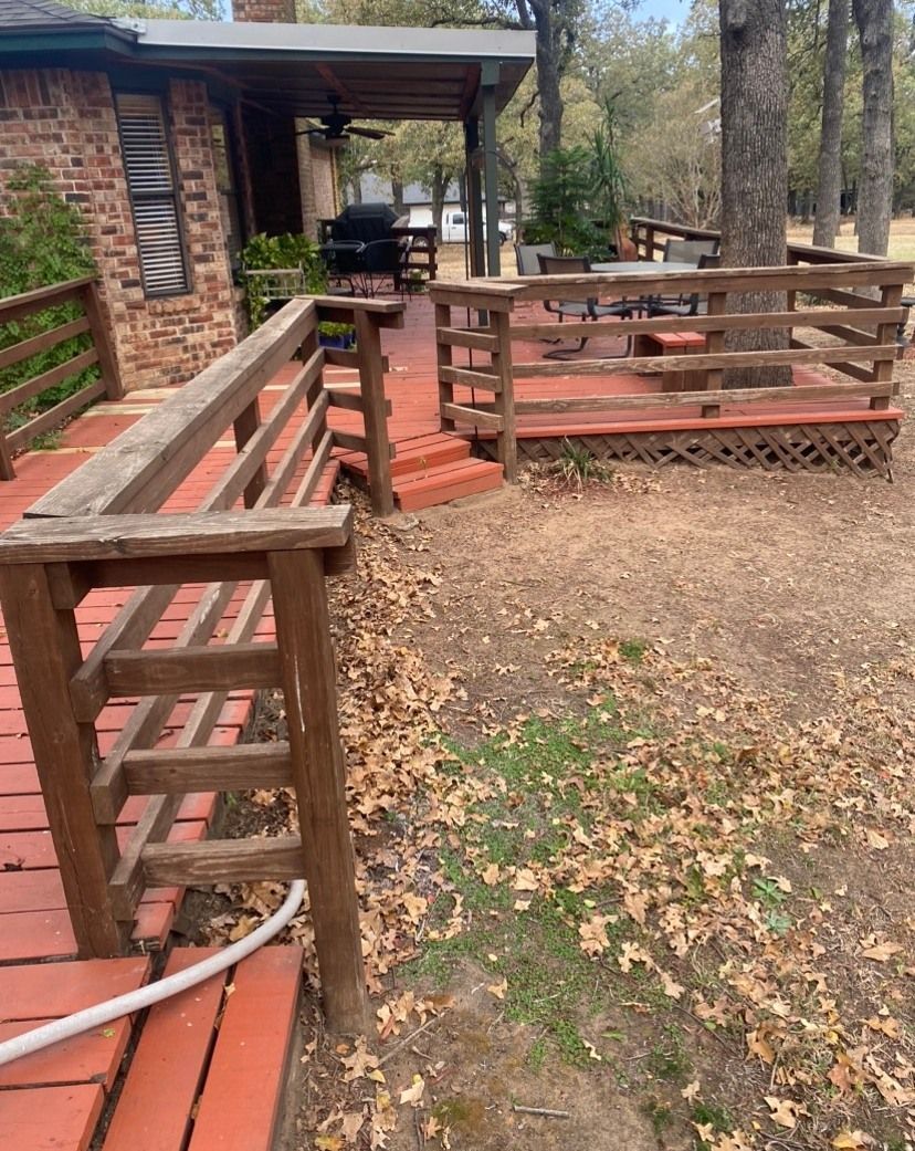 Red brick patio with weathered wooden railings, leading to a deck and backyard.