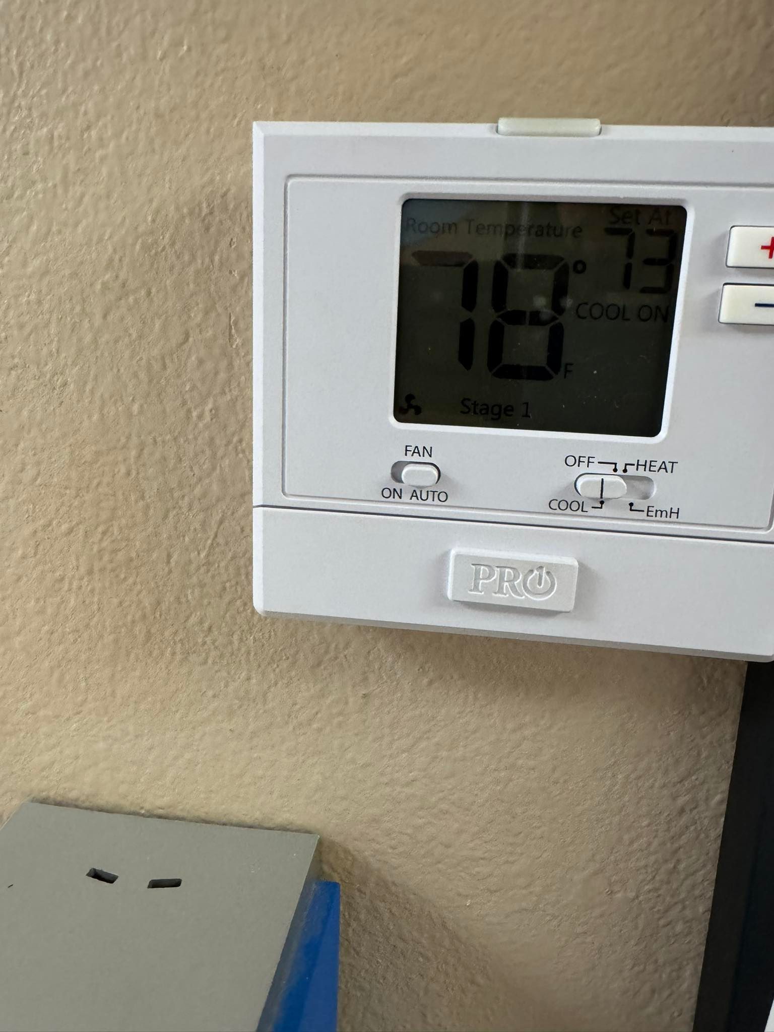 Thermostat on a tan wall displaying 78 degrees. The set point is 73 degrees.
