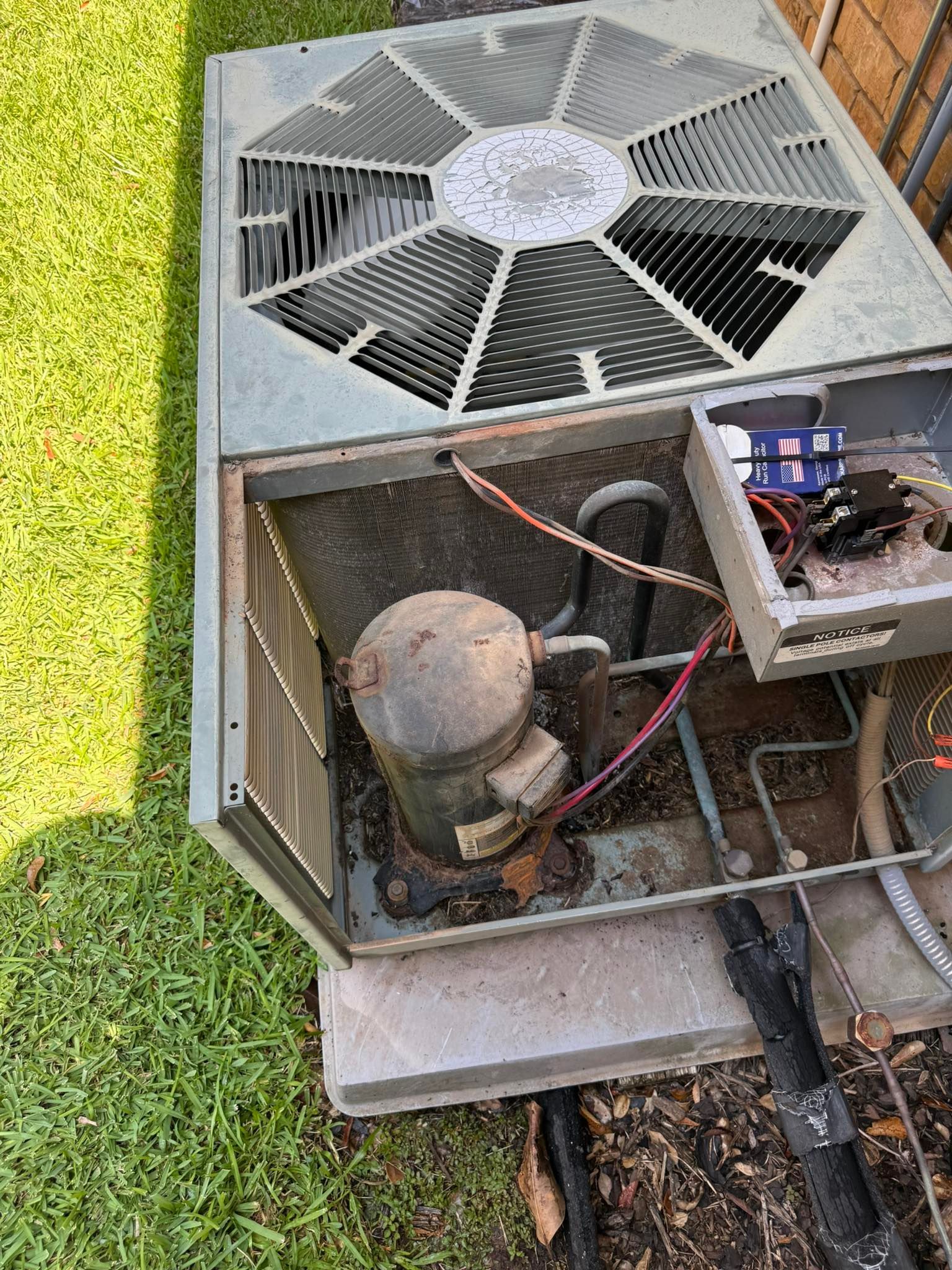 Open air conditioner with exposed internal components, outdoors.