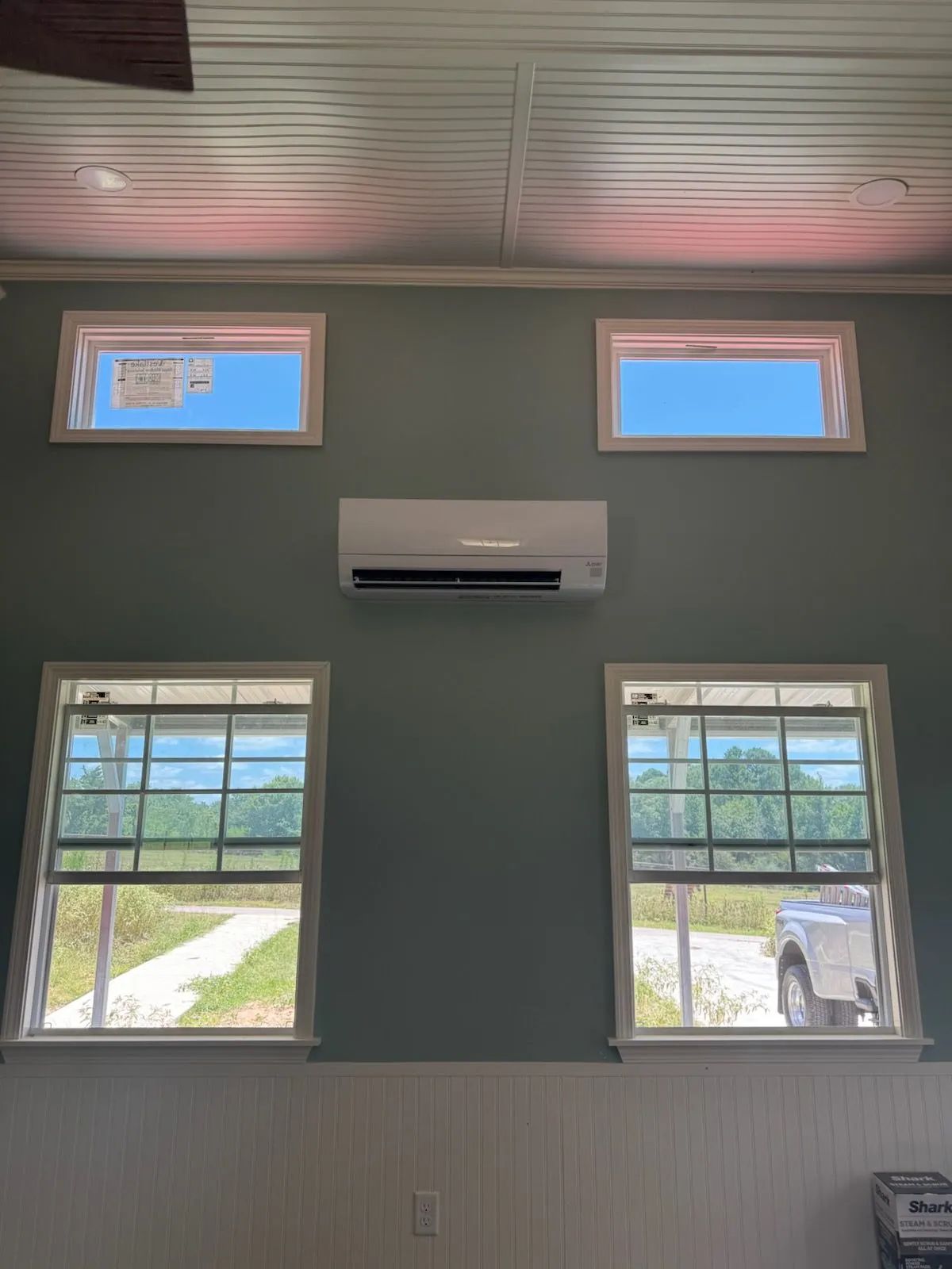 Light blue wall with windows and an air conditioning unit.