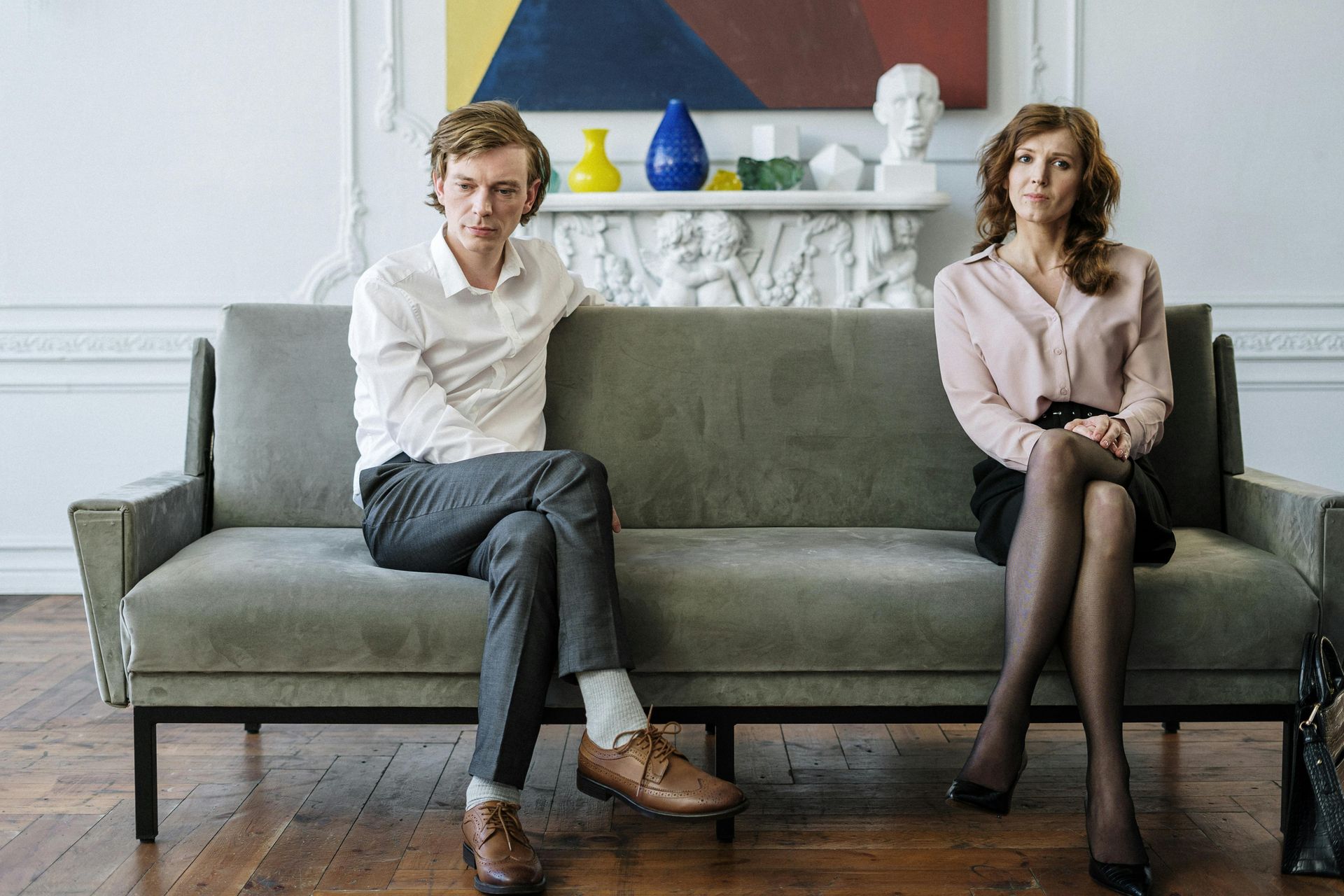 A man and a woman are sitting on a couch looking at each other.