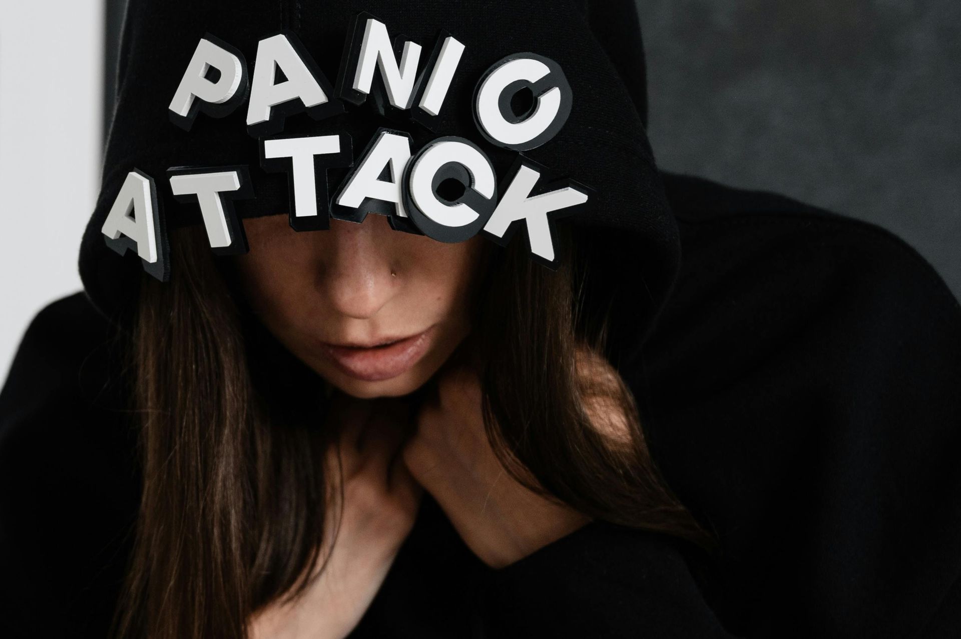 A woman wearing a black hoodie that says panic attack on it.