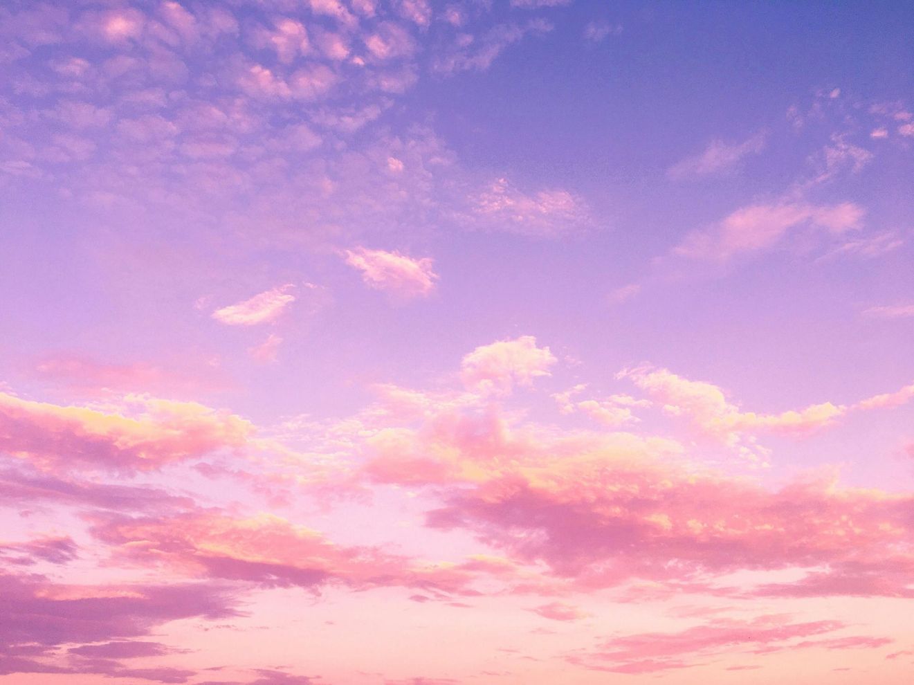 A sunset with pink clouds in a blue sky