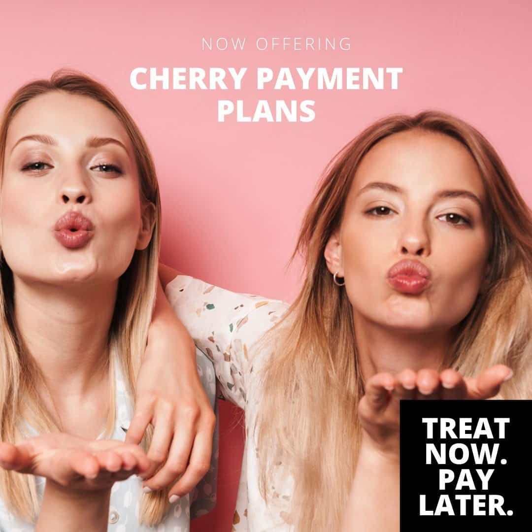 Two women blowing kisses in front of a pink background that says cherry payment plans