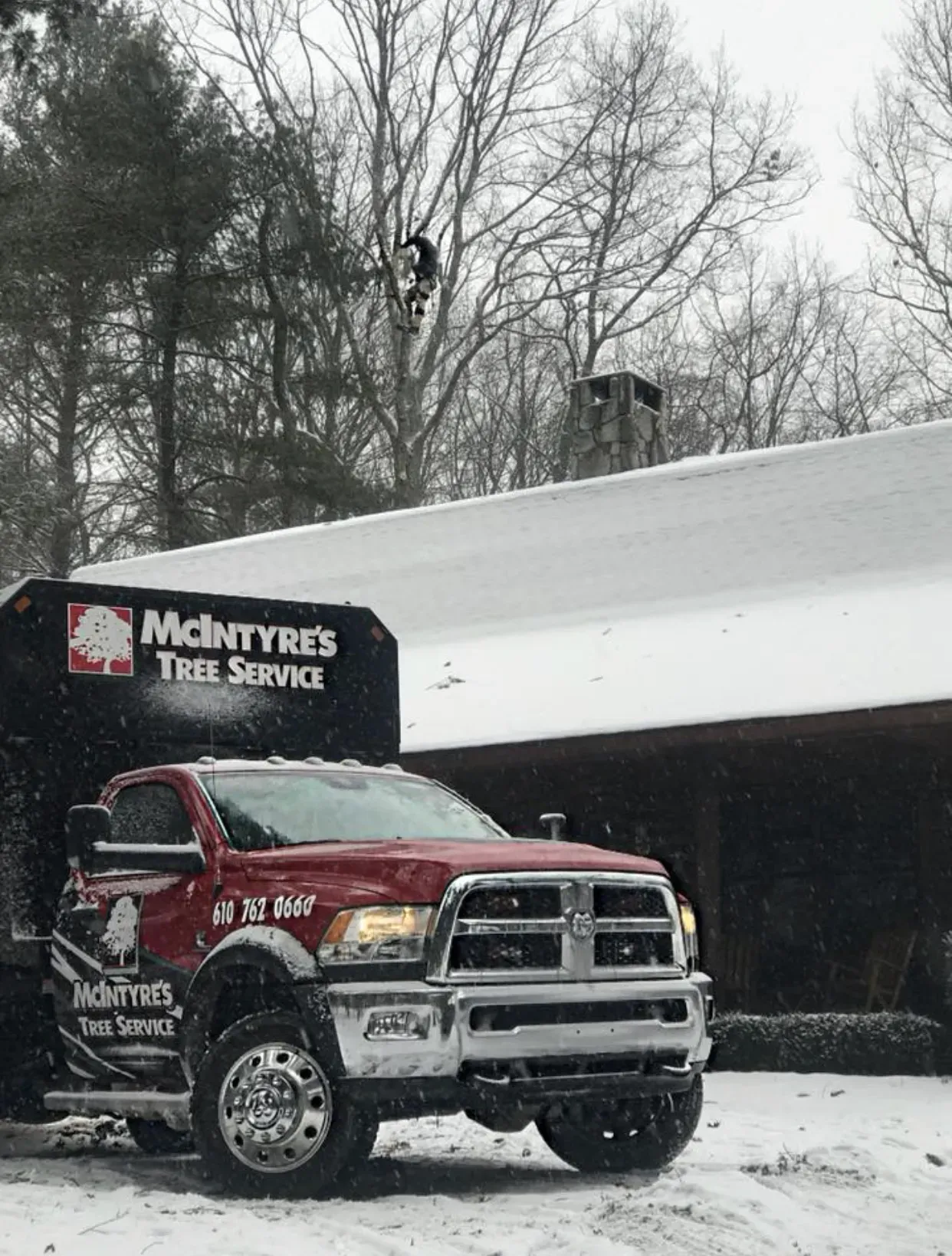 A red truck is parked in the snow in front of a building.