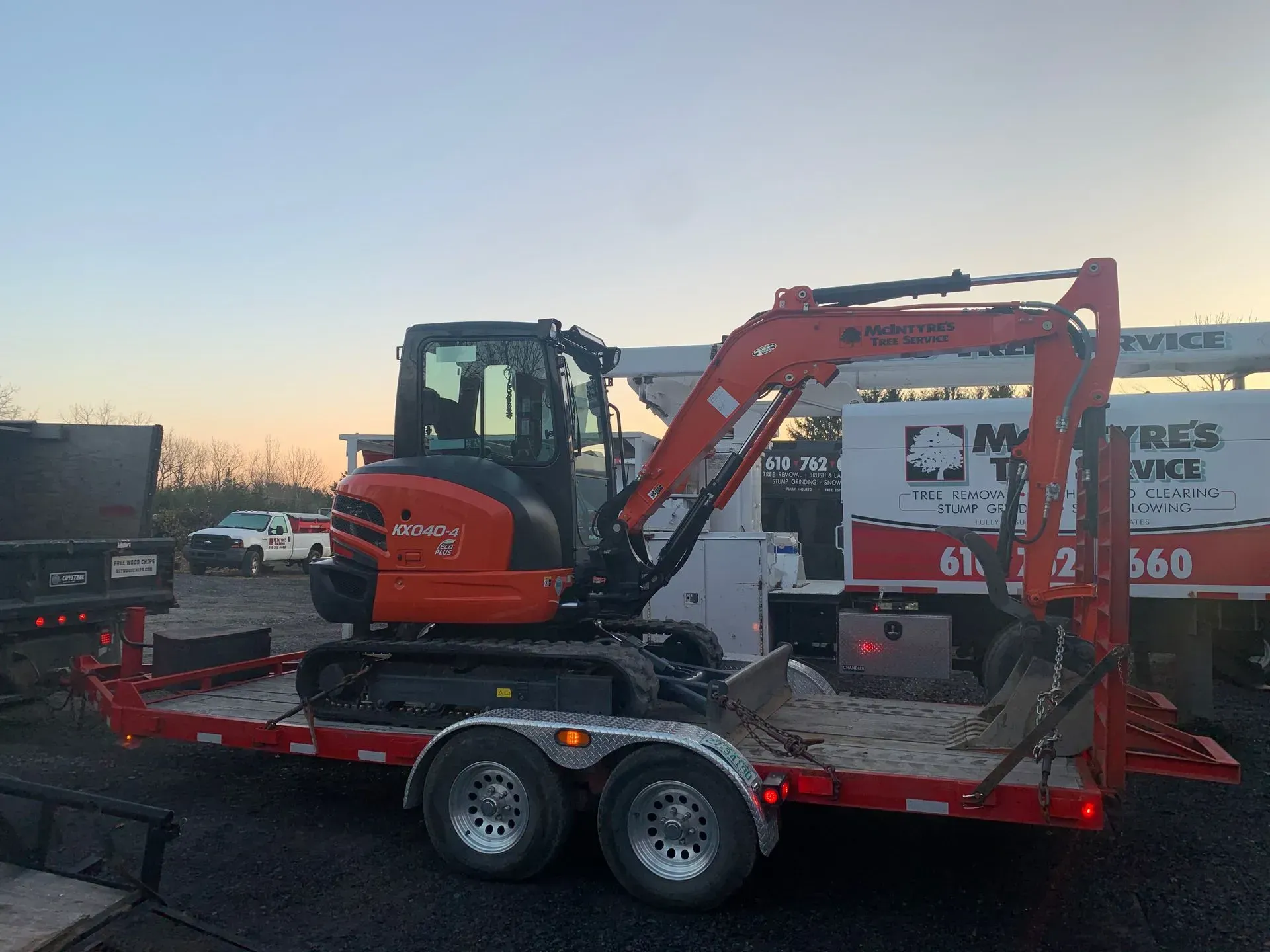 A small excavator is sitting on top of a trailer.