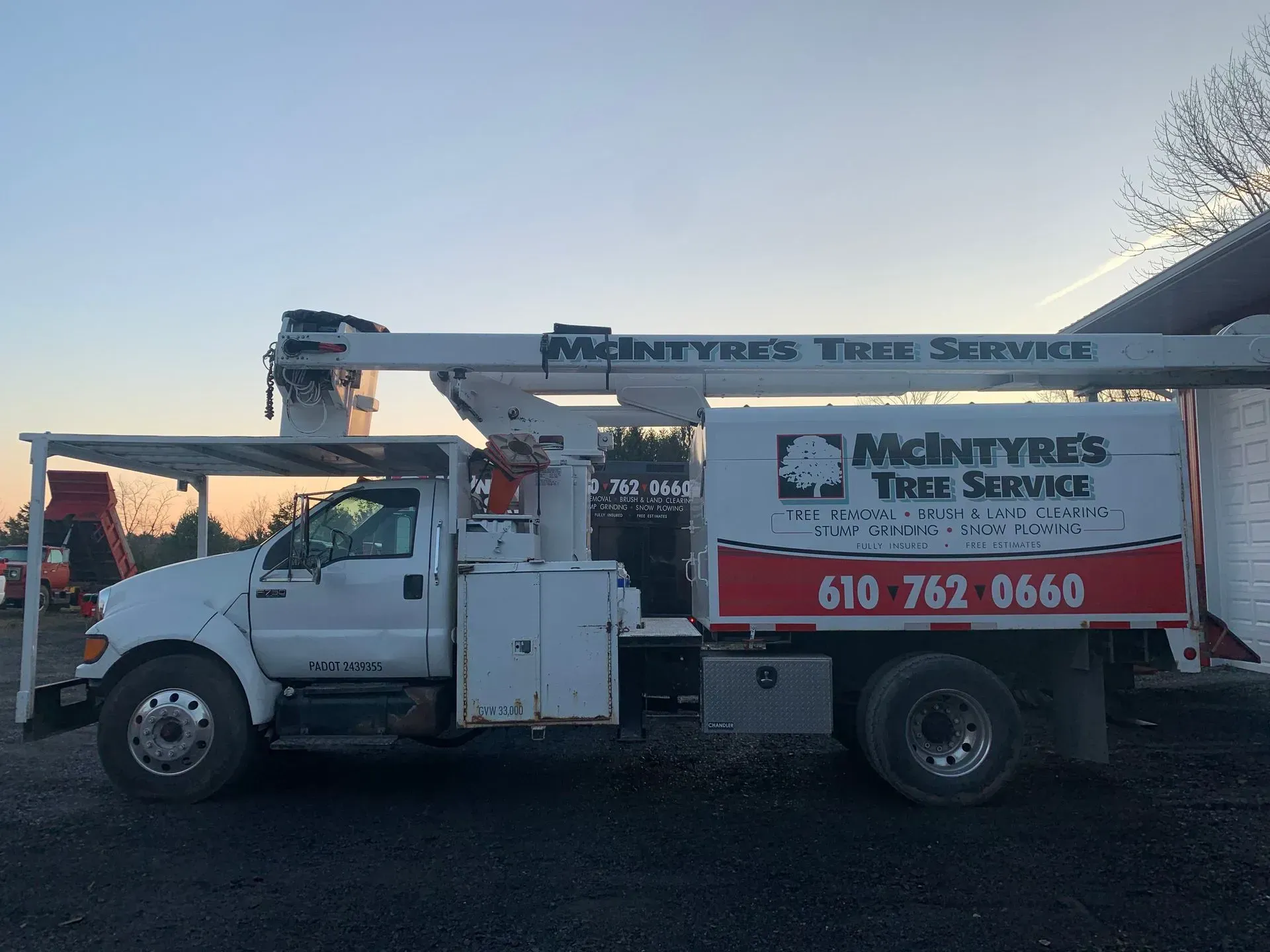 A mcintyre 's tree service truck is parked in front of a building