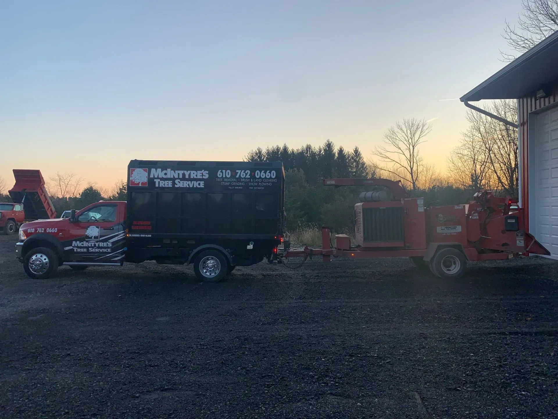 A truck with a trailer attached to it is parked in front of a building.
