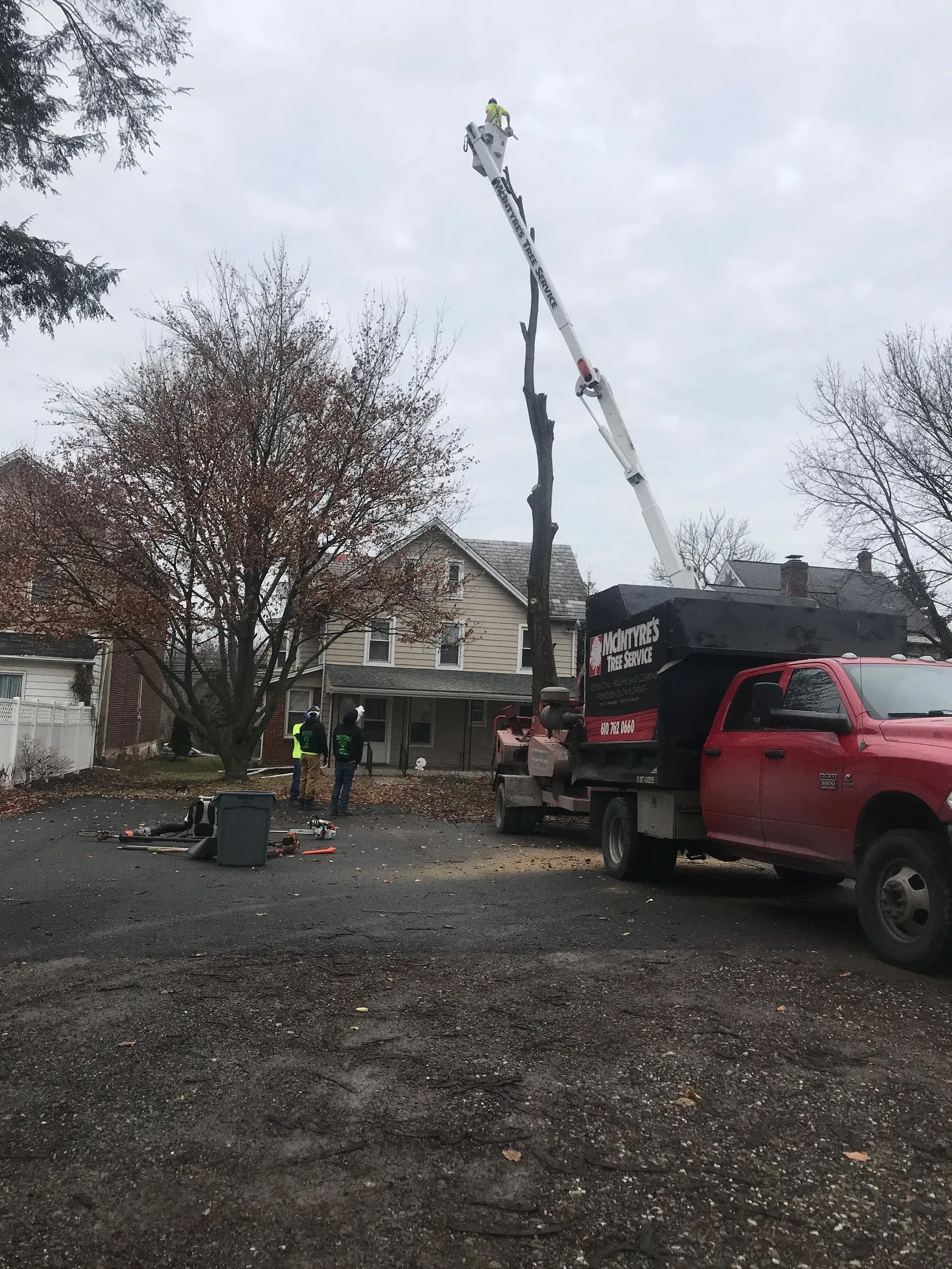A red truck with a crane on top of it is parked in a parking lot.