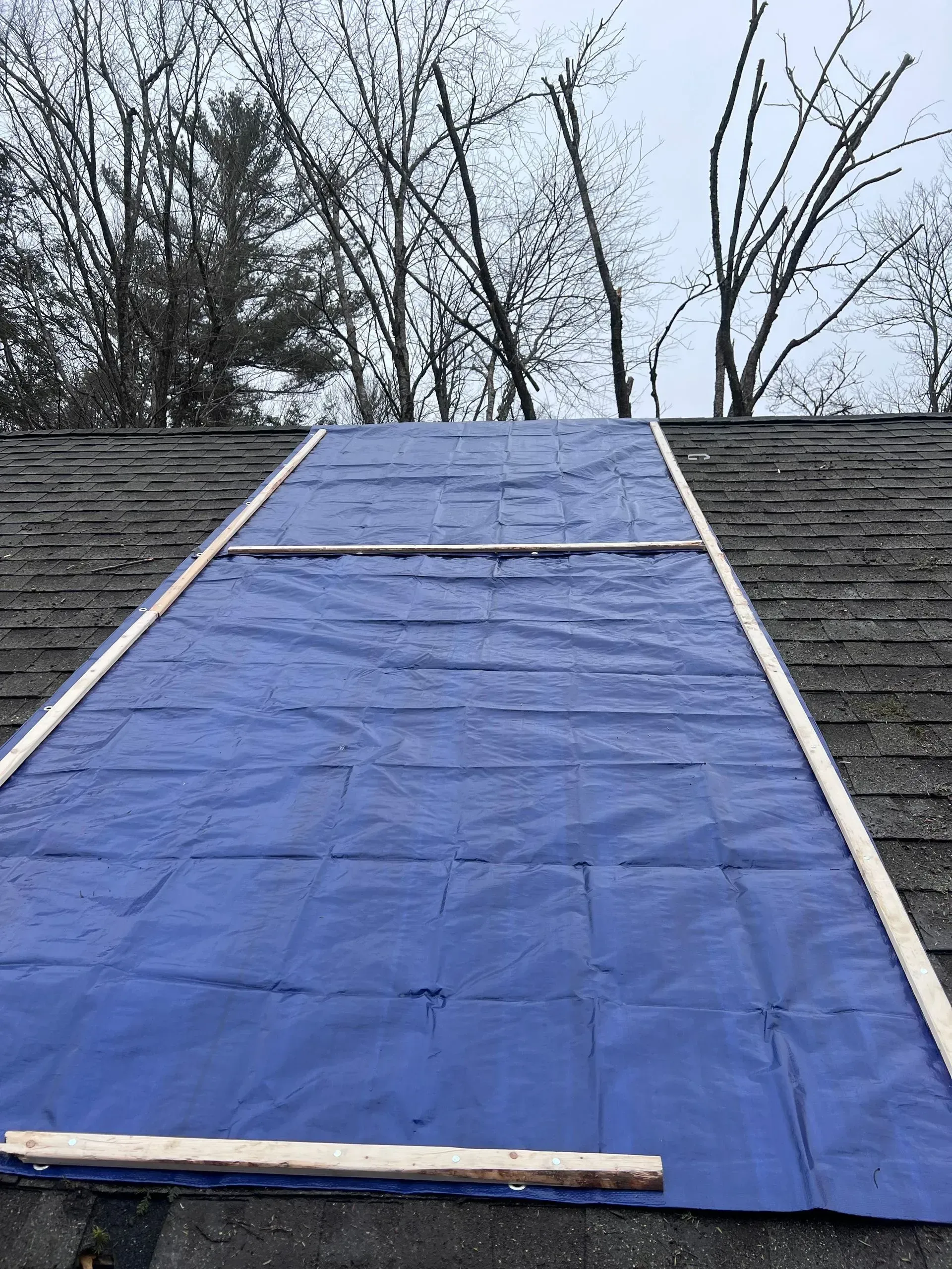A blue tarp is sitting on top of a roof.