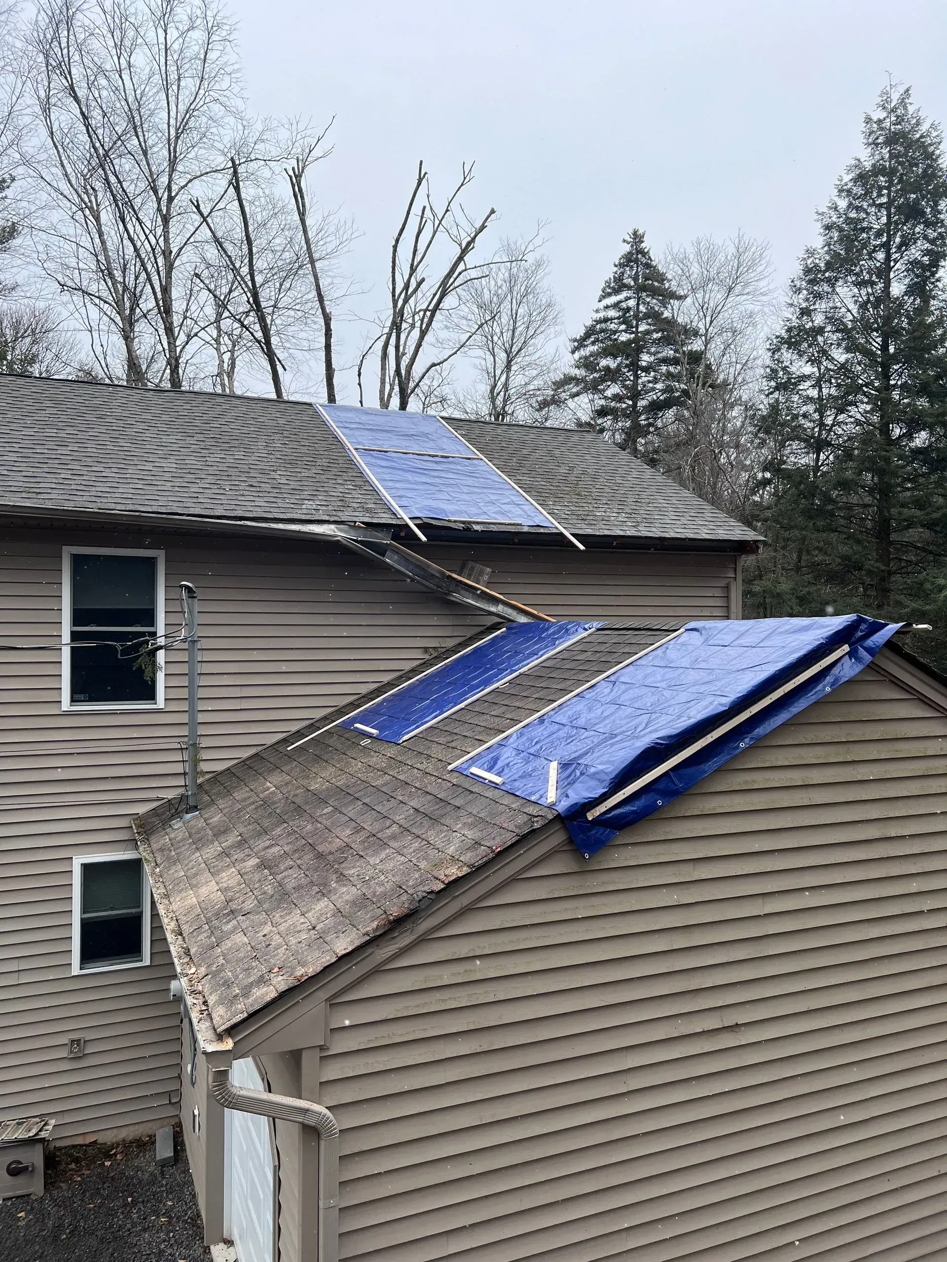 A house with a blue tarp on the roof.