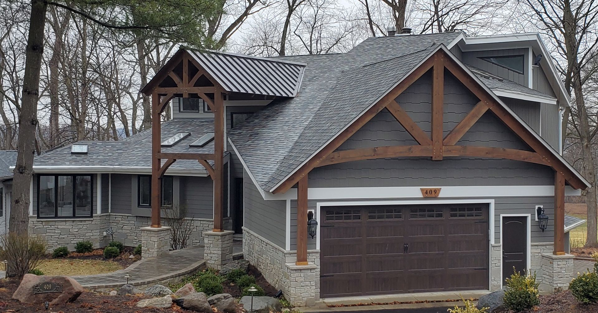 A large house with a gray roof and a brown garage door