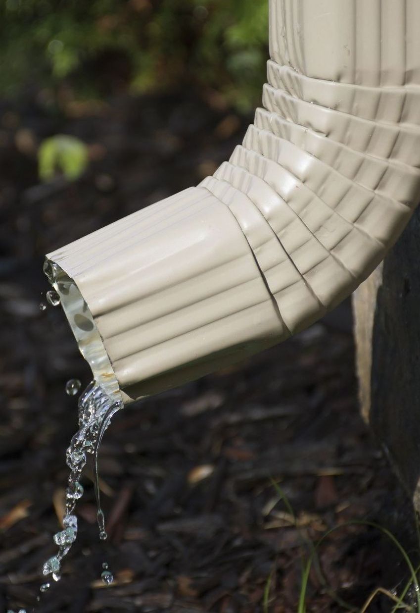 A close up of a gutter with water coming out of it