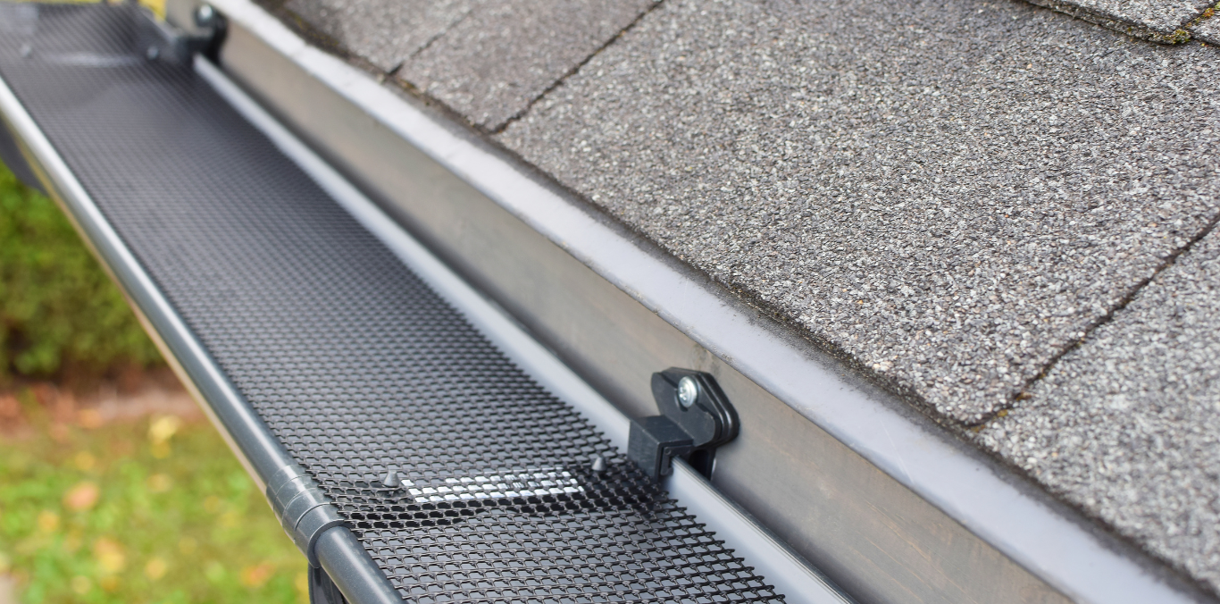 A close up of a gutter on the roof of a house.