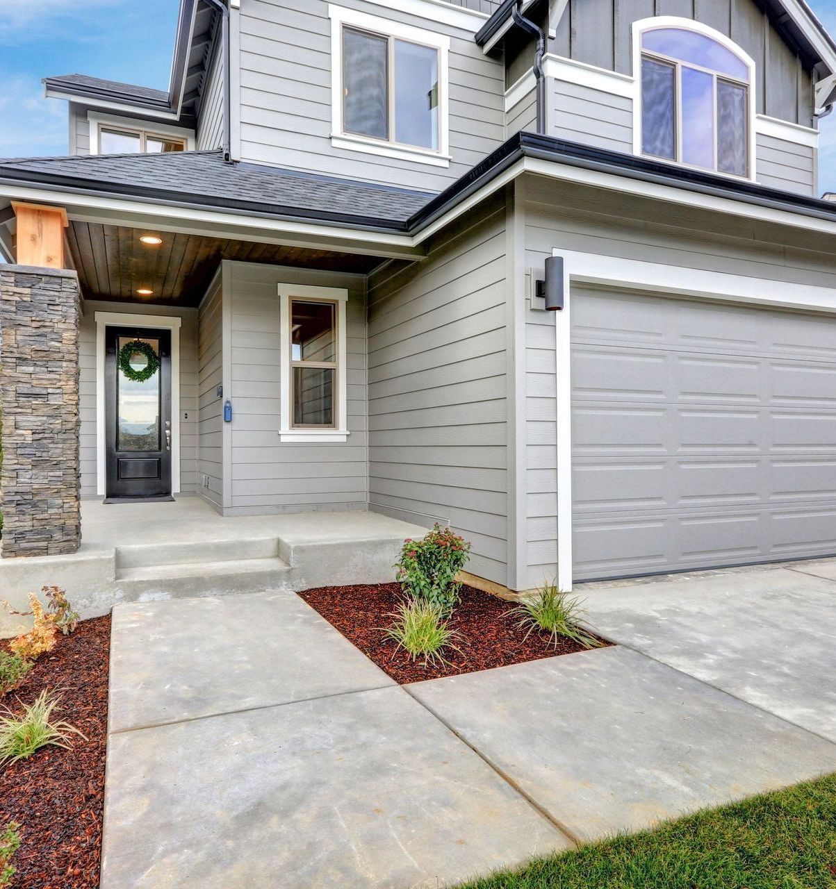 A gray house with a wreath on the door