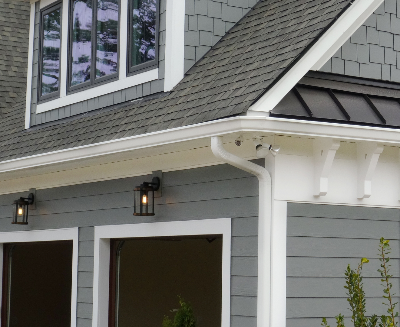 A gray house with a black roof and white trim