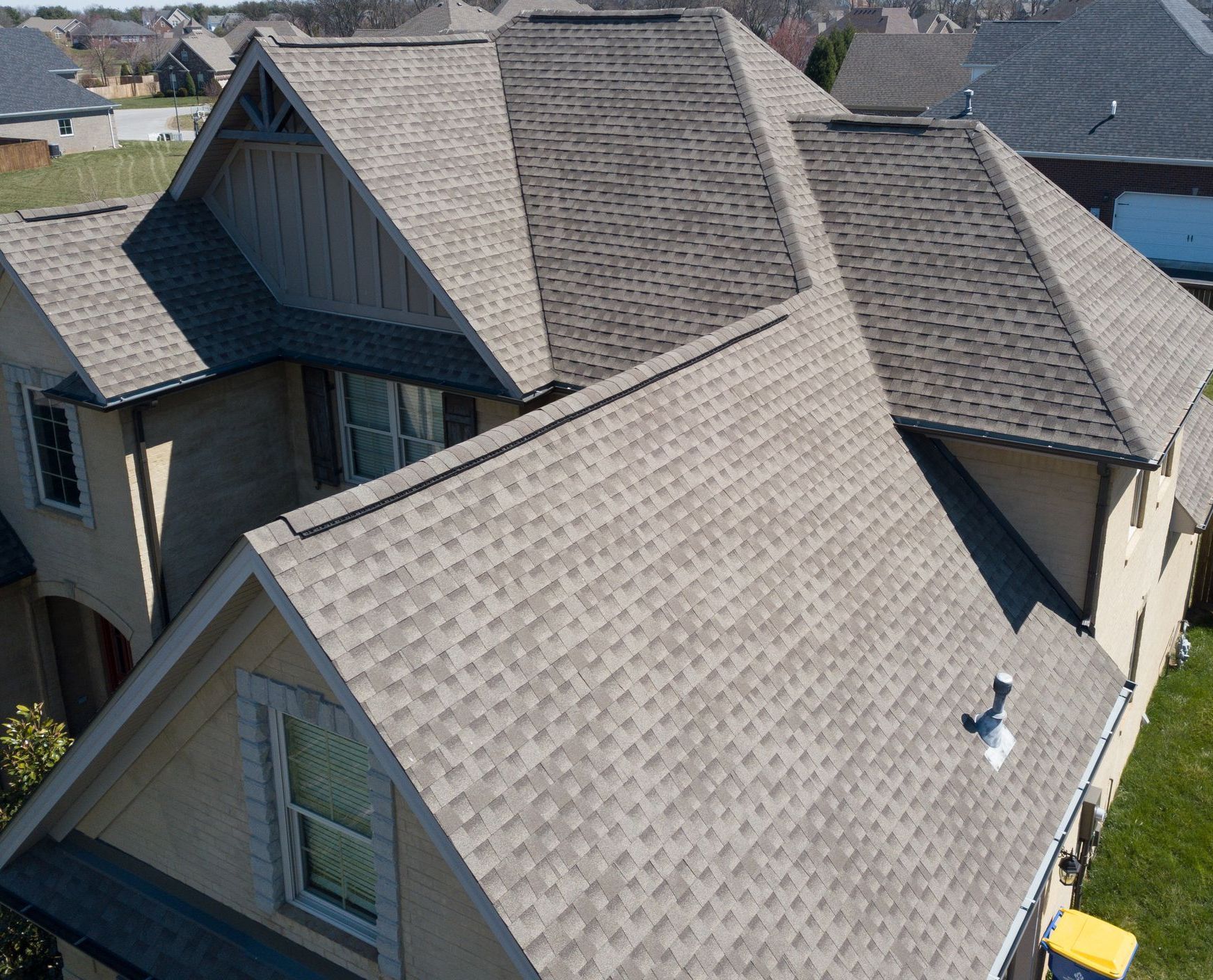 An aerial view of a large house with a gray roof.
