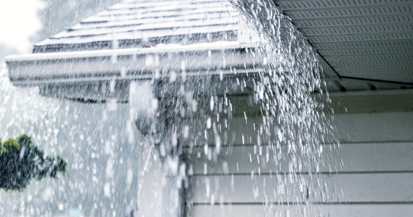 Rain is falling from the roof of a house.