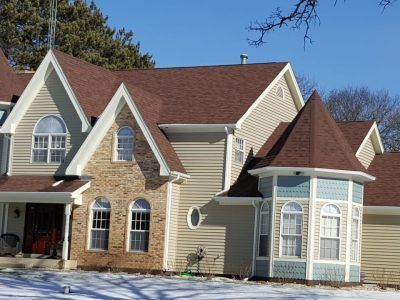 A large house with a brown roof and a lot of windows