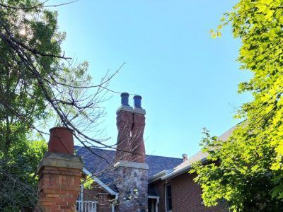 A brick house with two chimneys in front of it