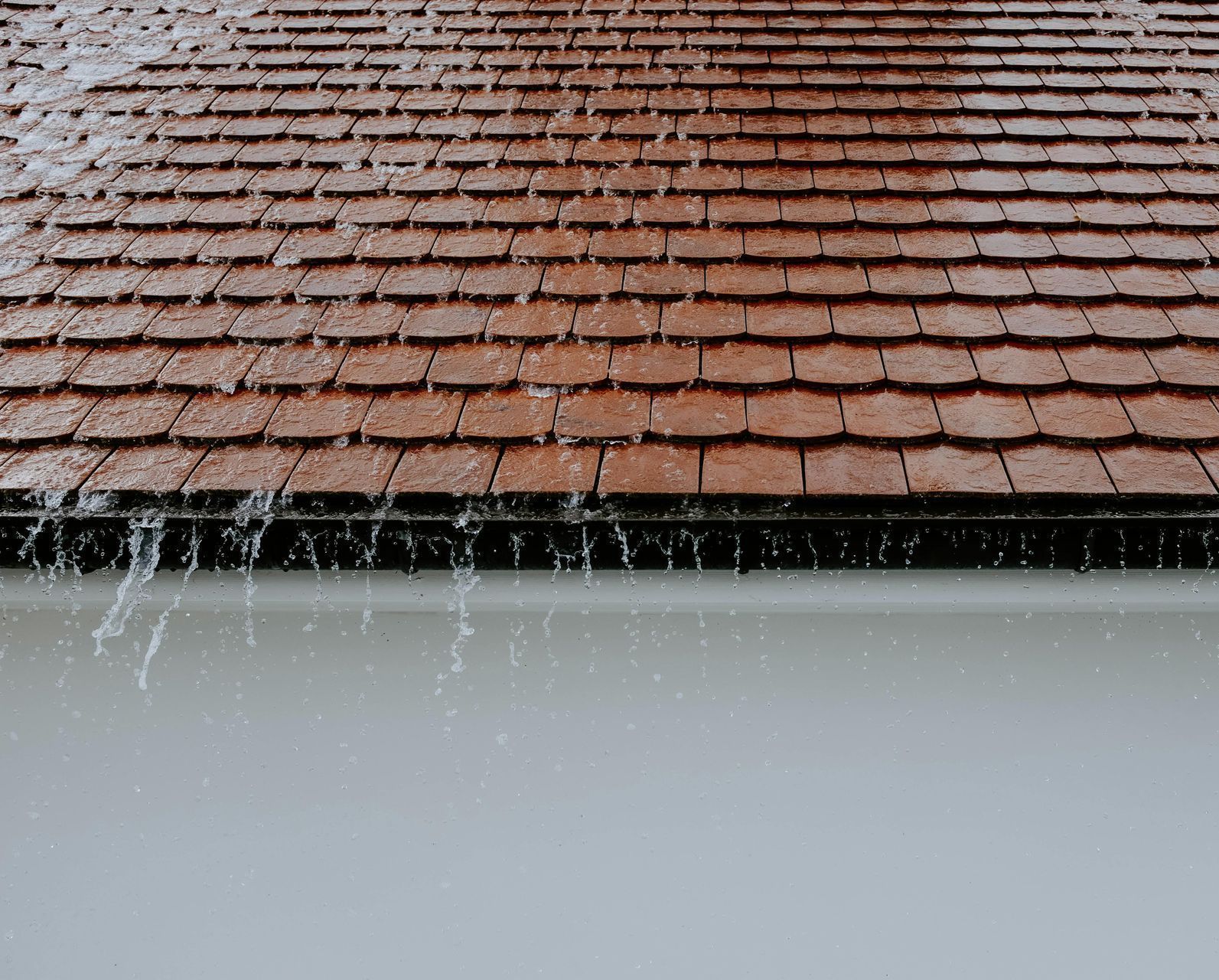 The rain is falling on the roof of a house.