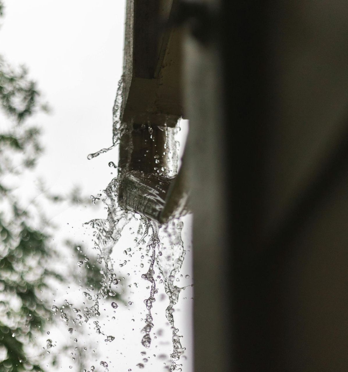 A close up of a gutter with water coming out of it