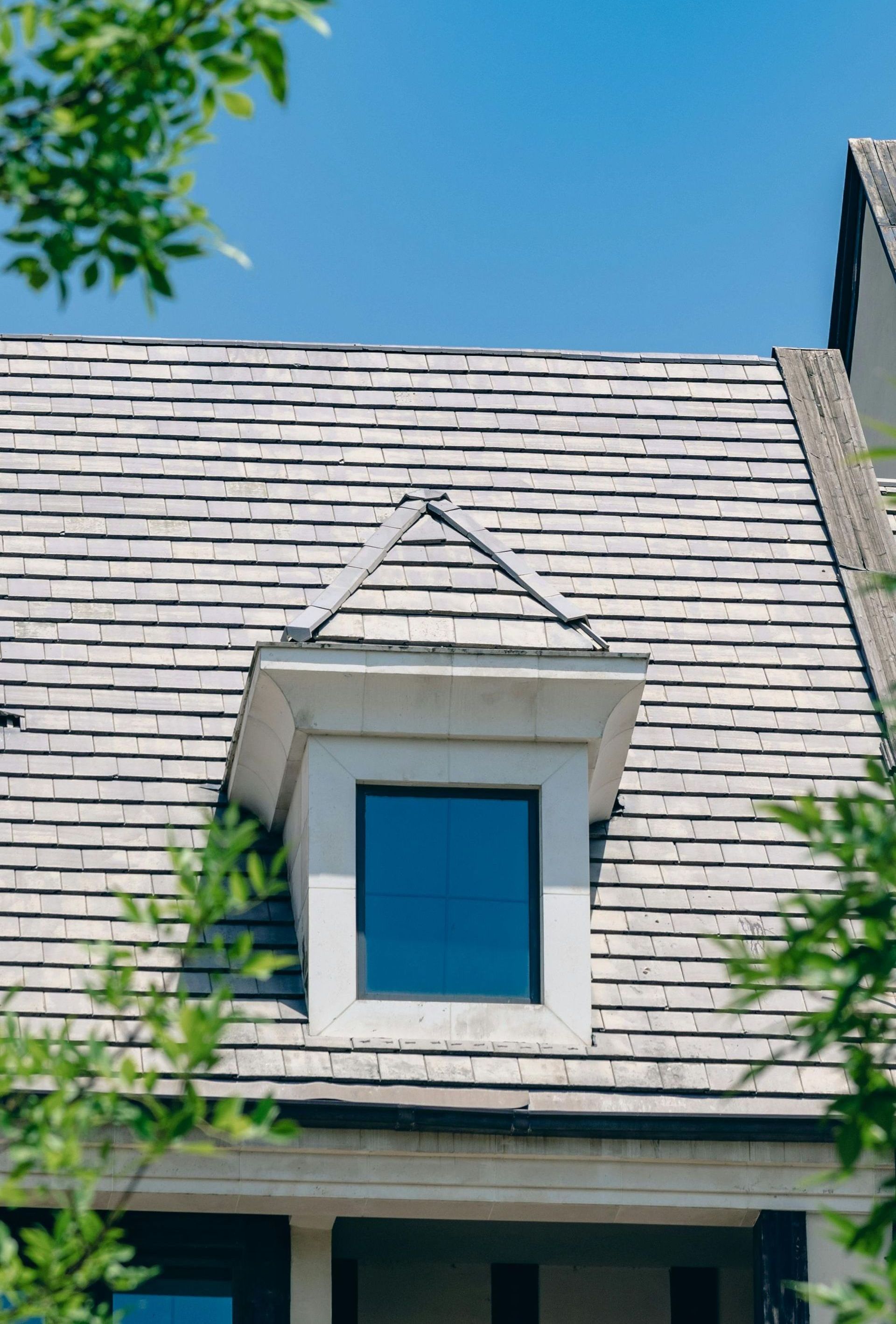 The roof of a house with a small window on it.