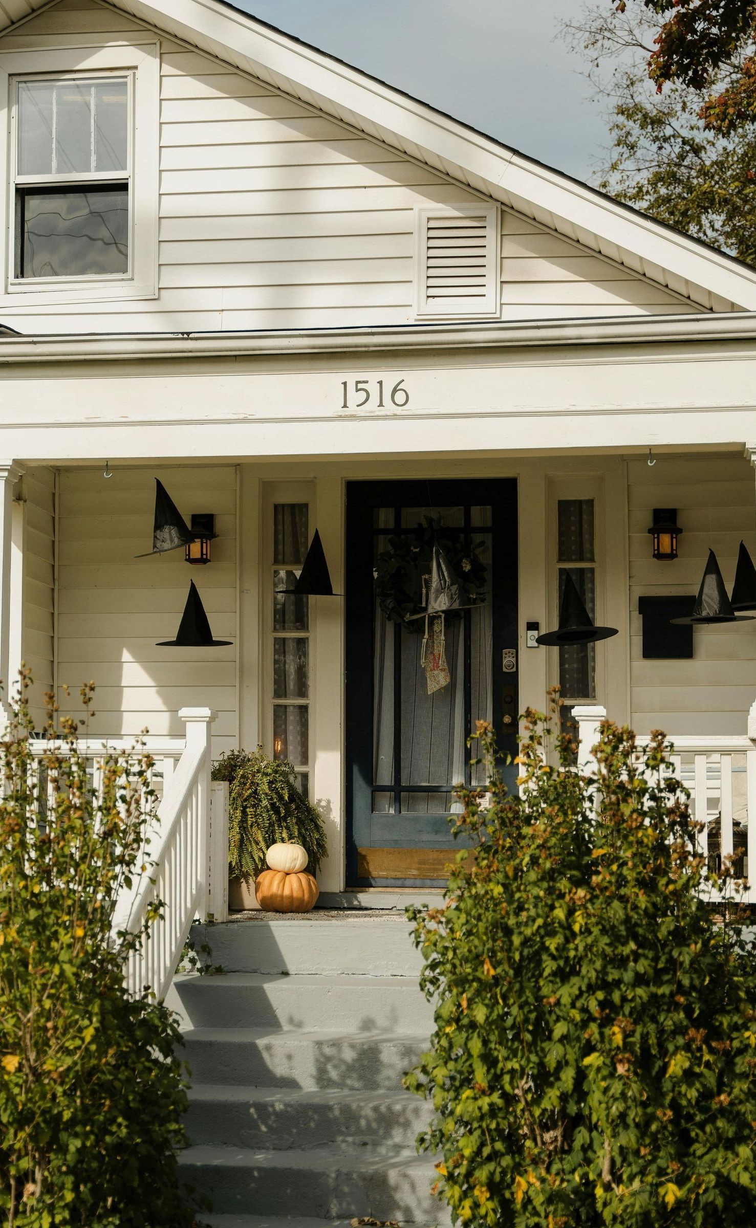 A white house with a porch decorated for halloween