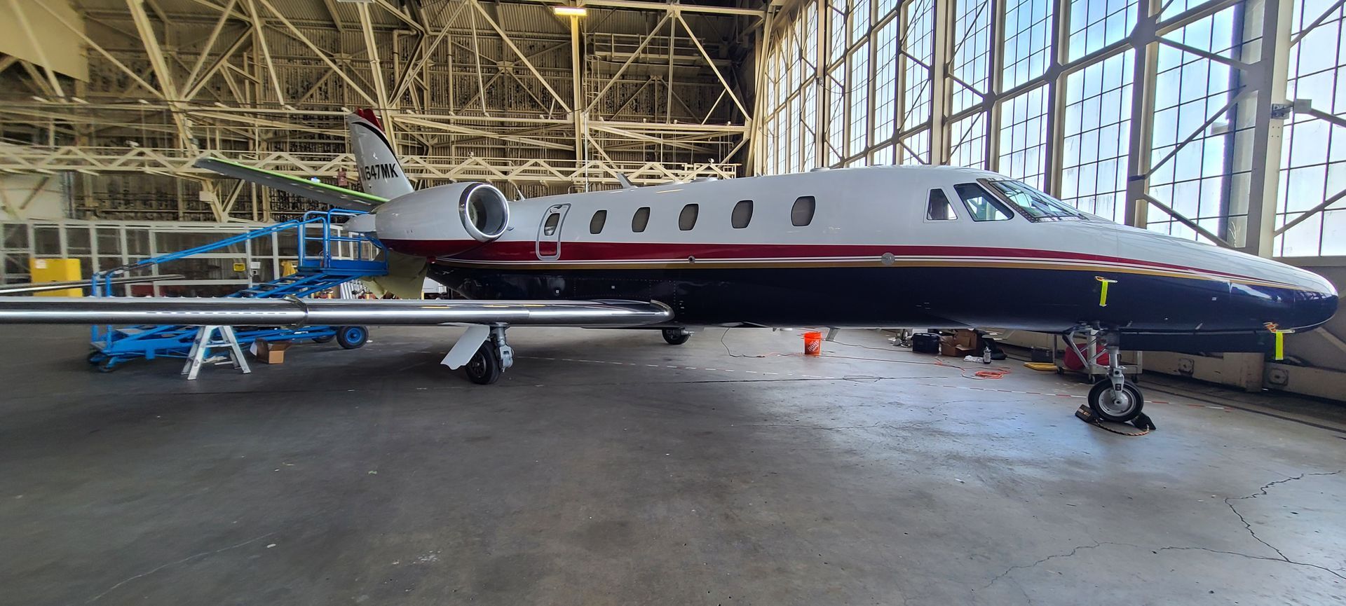 A small private jet is parked in a hangar.