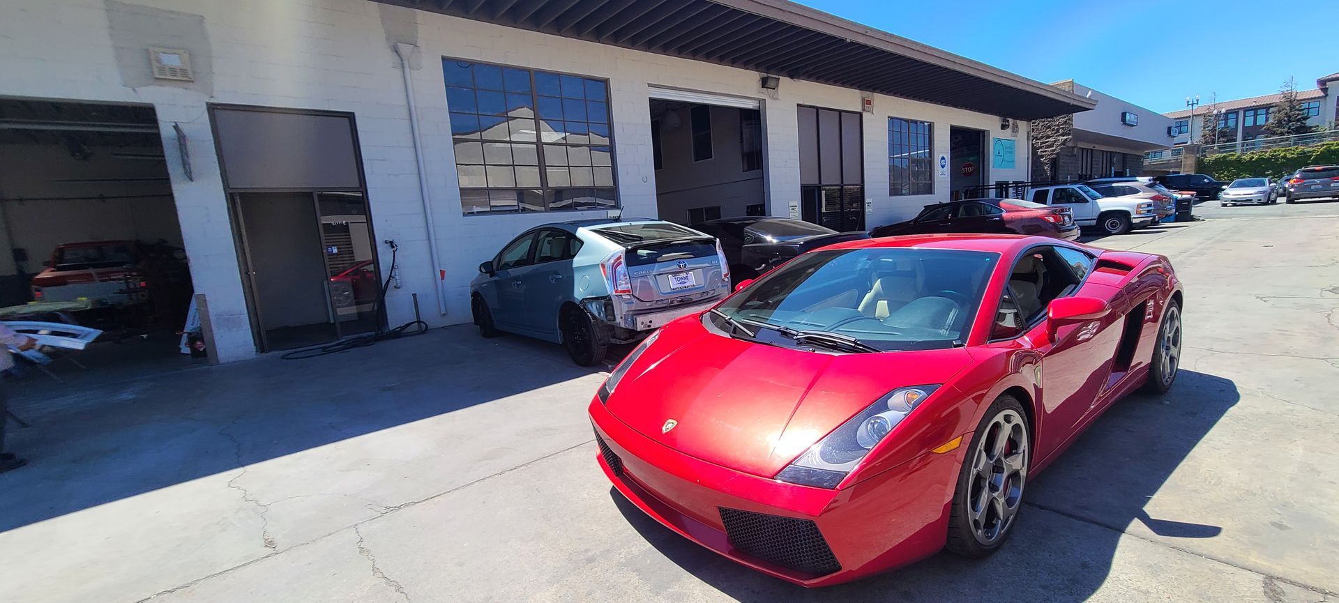 A red lamborghini gallardo is parked in front of a garage.