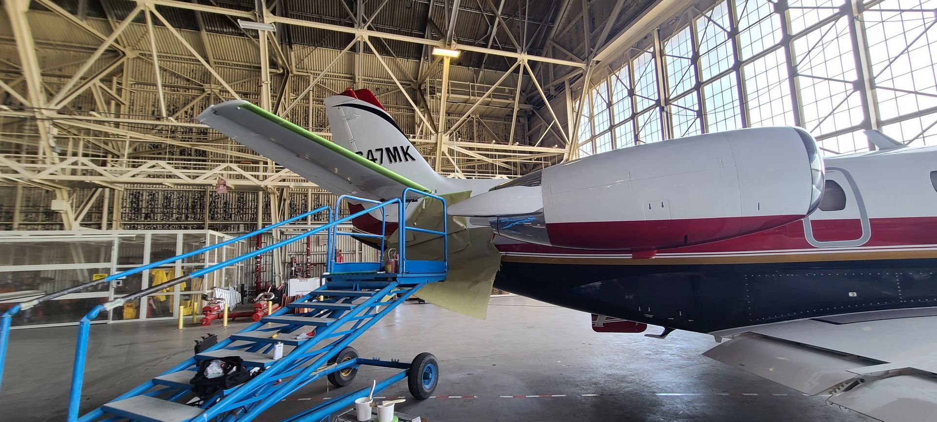 A plane is sitting in a hangar being worked on.