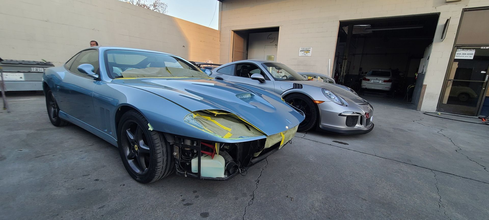 Two cars are parked next to each other in front of a garage.